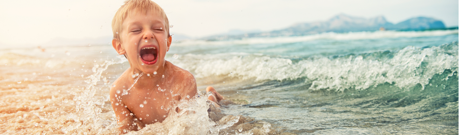 Laughing Boy at Beach - Southern California Surrogacy Blogs | 300 Spectrum Center Dr, Suite 400, Irvine, CA 92618 - (949) 878-8698